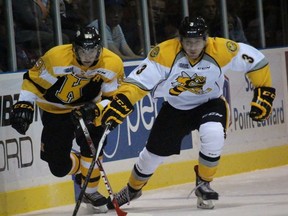 Kingston Frontenacs forward Spencer Watson and Sarnia Sting defenceman Alex Black race for a loose puck during the Ontario Hockey League game at the Sarnia Sports and Entertainment Centre Sunday afternoon. (Terry Bridge, The Observer)