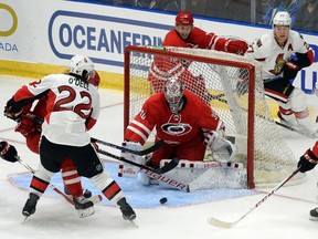 Caroline Hurricanes' goaltender Cam Ward, centre, watches a bouncing puck as players for both teams fight for position during an NHL exhibition game in St. John's, N.L, Sunday, Sept.27, 2015. THE CANADIAN PRESS/Keith Gosse