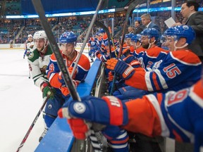 Minnesota Wild's Marco Scandella, left, hits Edmonton Oilers' Jordan Eberle in to his bench during the first period of an NHL pre-season hockey game in Saskatoon, Sask., on Saturday, September 26, 2015. THE CANADIAN PRESS/Liam Richards