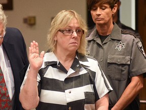 In this July 28, 2015 file photo, Joyce Mitchell raises her hand during a court appearance in Plattsburgh, N.Y. (Rob Fountain/The Press-Republican via AP, Pool, File)