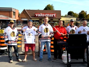 Members of the Mitchell Jr. C Hawks Evan Chaffe (left), Nick Jung, Brock Baier, captain Tyler Pauli, Steve Walkom and Hawks President Gus Eyers grilled up some hot dogs for their fans and gave away t-shirts and mini sticks to youngsters at a barbeque held last Saturday, Sept. 26 at Walkom's valu-mart downtown. GALEN SIMMONS/MITCHELL ADVOCATE