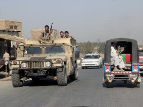 Afghan security forces travel on an armoured vehicle in Kunduz Province, Afghanistan September 28, 2015. Afghan Taliban fighters who launched a three-pronged assault on the northern provincial city of Kunduz have hoisted their white banner over the main square, a Reuters witness and two security officials said on Monday.  REUTERS/Stringer