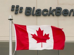 A BlackBerry logo hangs behind a Canadian flag at their offices in Waterloo. (REUTERS/Mark Blinch)
