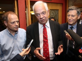 Flanked by Liberal candidates Kevin Lamoueux (l) and Terry Duguid, John McCallum (c) speaks about the party's platform on immigration during a media scrum in Winnipeg, Man. Monday Sept. 28, 2015.