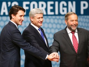 Liberal leader Justin Trudeau, Conservative leader and Prime Minister Stephen Harper and New Democratic Party (NDP) leader Thomas Mulcair (L-R) join hands before the Munk leaders' debate on Canada's foreign policy in Toronto, Canada September 28, 2015. REUTERS/Mark Blinch