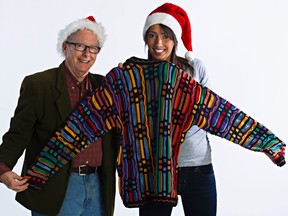 The  Sun's Graham Hicks, left, passes his Christmas sweater to reporter Claire Theobald for last year's Adopt-A-Teen campaign. Adopt-A-Teen is one beneficiary of the ATCO/Edmonton Sun Christmas Charity Auction. (EDMONTON SUN/File)