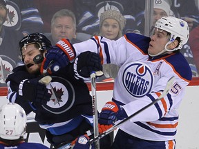 Oilers defenceman Mark Fayne (r) gives Winnipeg's Bryan Little a bit of grief (Brian Donogh/Postmedia Network).