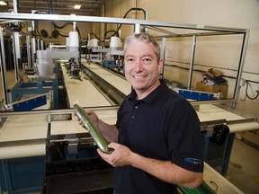 Gerard Regier, president of London?s Edge Automation, shows off the cucumber sorting and wrapping machine his company has designed. (DEREK RUTTAN, The London Free Press)