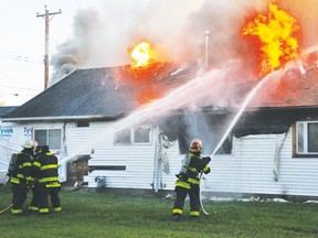 Vulcan firefighters douse flames at a house fire the morning of Sept. 28, 2015, in the 400 block of Centre St. Two people were later discovered dead inside the house.
Stephen Tipper/Postmedia Network