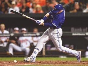 Blue Jays’ Justin Smoak hits a slow ground ball to drive in the winning run on a fielders choice last night in Baltimore. (AP)