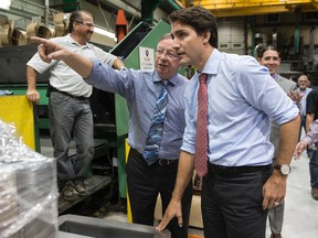 Liberal leader Justin Trudeau listens to company president Brian Klaponski as he tours an electric transformer manufacturer in Winnipeg on Sept. 29, 2015. (THE CANADIAN PRESS/Paul Chiasson)