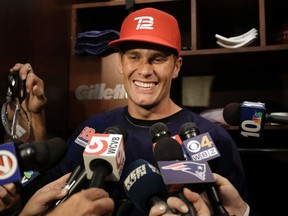 New England Patriots quarterback Tom Brady smiles while speaking with reporters in the locker room at Gillette Stadium before an NFL football practice in Foxboro, Mass., Sept. 23, 2015. (AP Photo/Steven Senne)