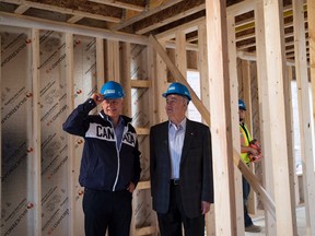 Conservative Leader Stephen Harper, left, and candidate Julian Fantinolook  over a new home construction site while making a campaign stop in Kleinburg Ont., on Tuesday, September 29, 2015. THE CANADIAN PRESS/Nathan Denette