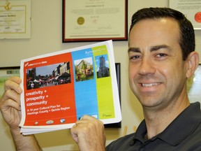 SARAH HYATT/THE INTELLIGENCER
Hastings County economic development manager, Andrew Redden, holds up the 10-year cultural plan for Hastings County and the Quinte Region at his Belleville office.