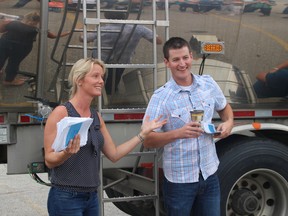 Amy Matheson, an Embro dairy farmer and spokesperson with the Oxford County Federation of Agriculture (left) and Andrew Campbell, a Strathroy dairy farmer, speak to the crowd gathered in front of a milk truck at a rally on Tuesday mornning. (MEGAN STACEY/Sentinel-Review)