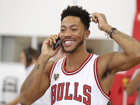 Chicago Bulls guard Derrick Rose laugh on the phone during NBA basketball media day Monday, Sept. 28, 2015, in Chicago. (AP Photo/Charles Rex Arbogast)