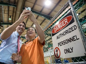 Liberal Leader Justin Trudeau takes a photo with a worker as he tours a electric transformer manufacturer,  Tuesday, September 29, 2015 in Winnipeg. THE CANADIAN PRESS/Paul Chiasson