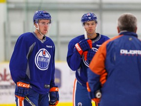 Oilers forwards Taylor Hall and Connor McDavid listen to coach Todd McLellan at the start of camp. McLellan has kept Hall and McDavid together throughout camp, something the players thinks helps them build chemistry. (Ian Kucerak, Edmonton Sun)