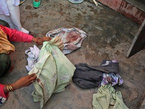 A relative displays the blood-soaked clothes of 52-year-old Muslim farmer Mohammad Akhlaq at his home in Bisara, a village about 45 kilometers (25 miles) southeast of the Indian capital of New Delhi, Wednesday, Sept. 30, 2015. (AP Photo/Manish Swarup)
