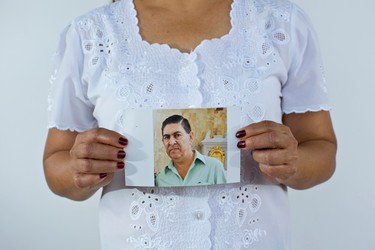 In this June 2, 2015 photo, Yolanda Alvarez Antunez holds up an image of her husband, Luis Alberto Ramirez Castillo, in Iguala, Mexico. Her husband was 54 years old when he was kidnapped by armed men outside of his home on Jan. 10, 2013. While trying to pay for the ransom, Yolanda herself was taken by the kidnappers and had to pay extra to be freed. (AP Photo/Dario Lopez-Mills)
