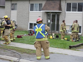 Kingston firefighters exit a building on Conacher Drive where they were called to extinguish a fire in the laundry room in Kingston, Ont. on Tuesday September 29, 2015. Elliot Ferguson/Kingston Whig-Standard/Postmedia Network