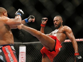 This Jan. 3, 2015 file photo Jon Jones, right, kicks Daniel Cormier during their light heavyweight title mixed martial arts bout at UFC 182, in Las Vegas. Jones pleaded guilty Tuesday, Sept. 29, to a charge stemming from a hit-and-run crash in Albuquerque that injured a pregnant woman, saying he took full responsibility for what the judge called a “stupid decision” in the moments following the accident. (AP Photo/John Locher, File)