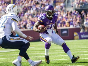 Vikings running back Adrian Peterson (right) carries the ball during third quarter NFL action against the Chargers at TCF Bank Stadium in Minneapolis on Sept. 27, 2015. (Brace Hemmelgarn/USA TODAY Sports)