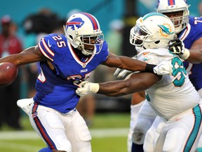 Buffalo Bills running back LeSean McCoy (25) is tackled by Miami Dolphins defensive tackle Earl Mitchell (90) during the first half at Sun Life Stadium. Steve Mitchell-USA TODAY Sports