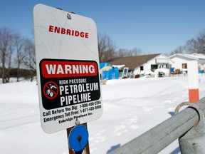 A sign warning of high pressure petroleum pipeline is seen on the Line 9 Enbridge oil pipeline route near Belleville, Ont., in this March 7, 2014 file photo. (Postmedia Network files)