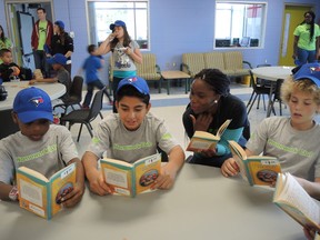 Members of the Boys and Girls Club of Ottawa in Vanier, now officially re-opened as "the Don McGahan Clubhouse," read with volunteers and staff.  (JULIENNE BAY/OTTAWA SUN)