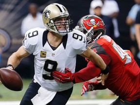 New Orleans Saints quarterback Drew Brees scrambles under pressure from Tampa Bay Buccaneers defensive end George Johnson in New Orleans, Sunday, Sept. 20, 2015. (AP Photo/Bill Haber)