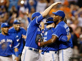 Blue Jays relief pitcher LaTroy Hawkins, right, celebrates with catcher Russell Martin, second from left, and teammate Chris Colabello after closing out the first game of a doubleheader against the Orioles in Baltimore on Wednesday, Sept. 30, 2015. (AP Photo/Patrick Semansky)