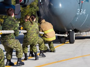 One of the 13 teams participating in the Hercules (Herc) Pull challenge at 8 Wing Trenton attempt to pull the 95,370 lbs. of aircraft and fuel with the fastest time on Thursday October 1, 2015 in Trenton, Ont. The annual event raises funds for the Government of Canada Workplace Charitable Campaign (GCWCC) Tim Miller/Belleville Intelligencer/Postmedia Network
