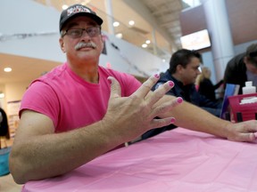 EMILY MOUNTNEY-LESSARD/THE INTELLIGENCER
Ed Keuning gets his nails painted pink at the Quinte Sports and Wellness Centre, on Thursday in Belleville. Members of the Belleville Fire Department volunteered for the pink manicures to raise awareness of breast cancer.