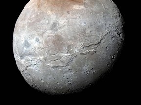 This image released by NASA on Thursday, Oct. 1, 2015, shows Charon, in enhanced color by captured by NASA's New Horizons captured just before closest approach on July 14, 2015. Massive canyons and fractures are clearly visible on Charon, which is more than half of Pluto’s size.  (NASA/JHUAPL/SwRI via AP)