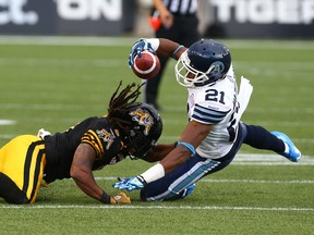 Argos receiver Vidal Hazelton (right) is taken down by Rico Murray of the Tiger-Cats during CFL action in Hamilton on Aug. 3, 2015. (Dave Abel/Toronto Sun)