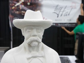 A statue of Jack Daniel looks on as Alex Magcawas sets up The Hat Restro Pub booth prior to the Edmonton Oktoberfest at the Edmonton Expo Centre, in Edmonton Alta. on Thursday Oct. 1, 2015. David Bloom/Edmonton Sun/Postmedia Network