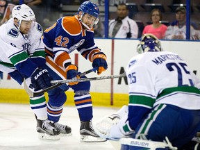 Oilers forward Anton Slepyshev tries to get a shot on the Vancouver Canucks' goalie Jacob Markstrom while battling Yannick Weber (6) during first period action at Rexall Place on Thursday. (David Bloom, Edmonton Sun)