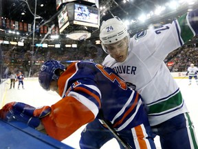 The Edmonton Oilers' Anton Lander (51) battles the Vancouver Canucks' Adam Cracknell (24) during first period NHL action at Rexall Place, in Edmonton Alta. on Thursday Oct. 1, 2015. David Bloom/Edmonton Sun/Postmedia Network