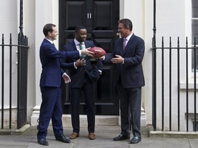 Britain's Finance Minister George Osborne meets with former American football players Dan Marino and Curtis Martin ahead of the New York Jets playing against the Miami Dolphins at London's Wembley Stadium on Sunday October 4, 2015. (AFP/JUSTIN TALLIS)