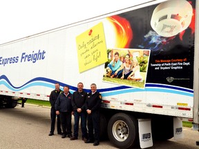 Through a partnership between the Perth East Fire Department and Woodcock Brothers Express Freight, with graphics donated by Snyders Graphics, a new tractor trailer has been outfitted with a message reminding people to ensure their smoke alarms are working properly. Pictured, from left: Perth East and West Perth fire prevention officer Todd McKone, owner of Woodcock Brother Express Freight Brad Woodcock, owner of Snyders' Graphics Shawn Snyders and Perth East and West Perth fire chief Bill Hunter. (GALEN SIMMONS/ The Mitchell Advocate)