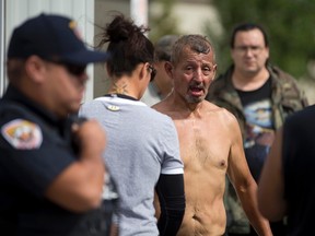 Pierre George stands shirtless after being engulfed in flames during a dispute between members of the Kettle and Stony Point First Nations at the entrance to the former army camp being returned by the federal government in Ipperwash, Ont. on Sept. 20, 2015. (Craig Glover/The London Free Press/Postmedia Network)