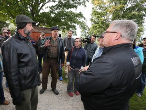 Raw milk advocate Michael Schmidt, centre, gestures as he speaks with a provincial agriculture investigator during a raid at Glencolton Farms, near Durham, Ont. Friday. After a standoff, provincial authorities agreed to leave items behind at the farm (James Masters/The Sun Times)