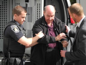 A handcuffed Brian Lucy is led from a police van to Brockville jail after being sentenced to five years in prison for indecent assault and gross indecency on Friday, October 2, 2015 in Brockvile, Ont.  Wayne Lowrie/Brockville Recorder and Times/Postmedia Network