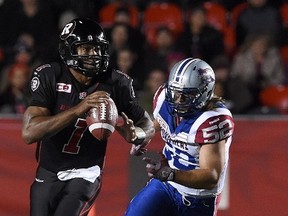 Ottawa Redblacks' Henry Burris looks for a pass as Montreal Alouettes' Nicolas Boulay runs towards him during third quarter CFL action in Ottawa on Thursday, Oct 1, 2015. THE CANADIAN PRESS/Sean Kilpatrick