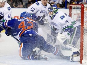 Anton Slepyshev crashes into Canucks goalie Jacob Markstrom during second-period action Thursday at Rexall Place. (The Canadian Press)