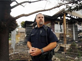 Luke Hendry/The Intelligencer
Belleville Police Det. Const. Pat Kellar stands outside a fire-ravaged home from which he and construction worker James Badgley rescued a man as it burned during a natural-gas fire in Belleville Friday. Kellar dismissed any suggestion his actions were heroic. "Right place, right time," he said.