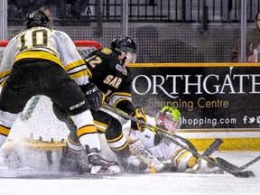 North Bay Battalion forward Brett Hargrave holds back Sarnia Sting forward Brandon Lindberg as goalie Jake Smith pounces on a loose puck during the Ontario Hockey League game at North Bay Memorial Gardens Friday night. Hargrave, a former Sarnia Sting draft pick, made his Battalion debut in a 5-4 victory for the home side. (Denis Dubois/Sarnia Observer/Postmedia Network)