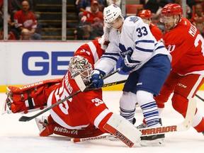 Toronto Maple Leafs centre Mark Arcobello (33) hits Detroit Red Wings goalie Jimmy Howard (35) as Drew Miller (20) defends in Detroit Friday, Oct. 2, 2015. (AP Photo/Paul Sancya)