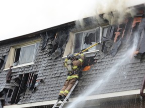 Firefighters spent hours battling a stubborn blaze at a Limberlost Road townhouse complex Saturday. Eight units were damaged but nobody was injured. DALE CARRUTHERS / THE LONDON FREE PRESS